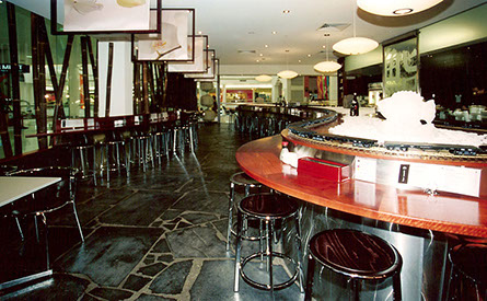 Curved solid timber high tables in Jarrah with stainless steel surround.