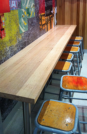 Solid timber tables, benches, columns and wall cladding.