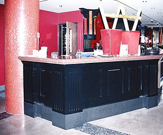 Routed painted panels with granite tops on bar and DJ booth and open shelving for bottle storage.