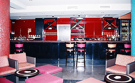 Routed painted panels with granite tops on bar and DJ booth and open shelving for bottle storage.